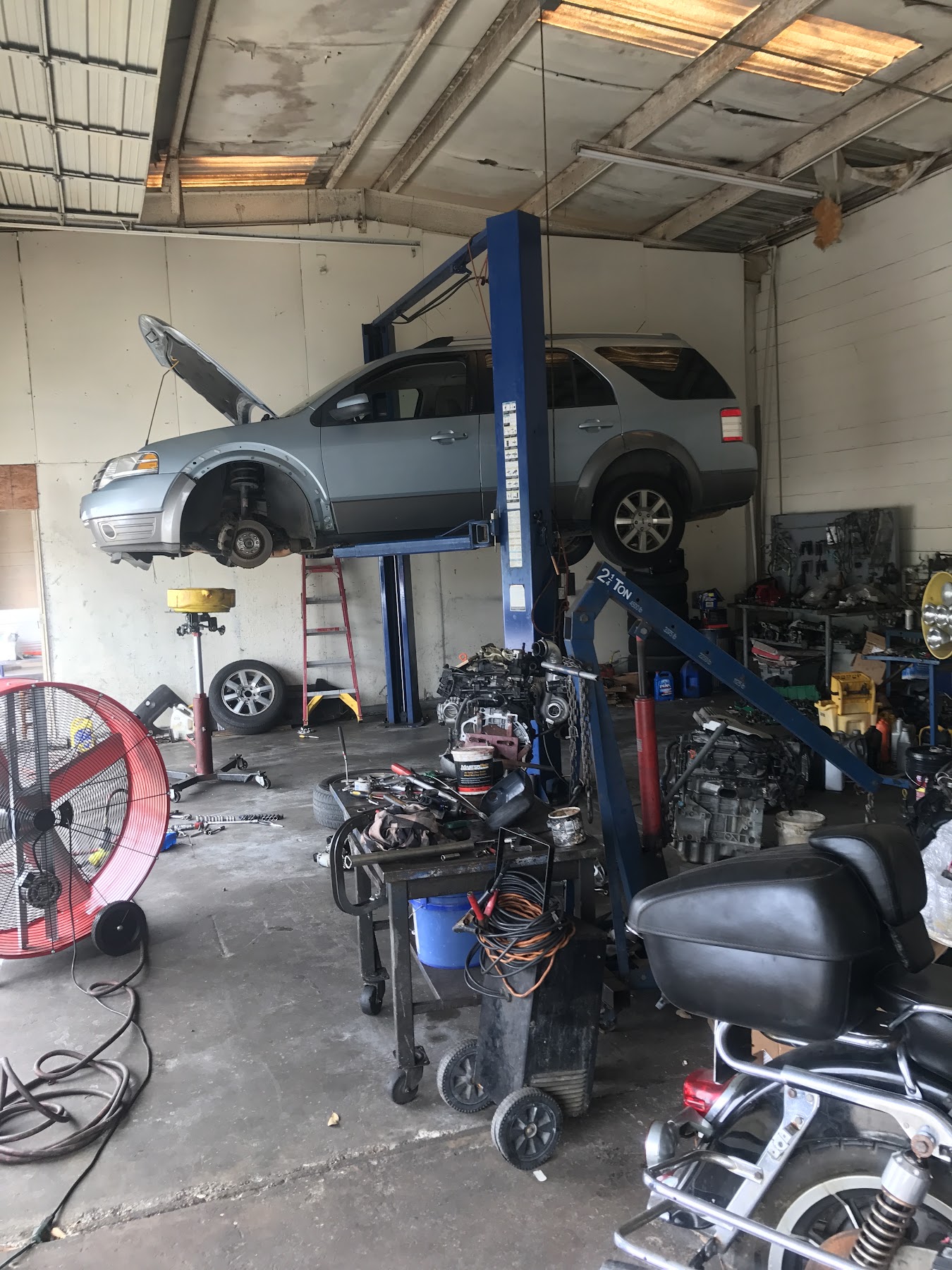 Inside the D and M Auto Repair shop with a vehicle raised on a lift and tools at the ready