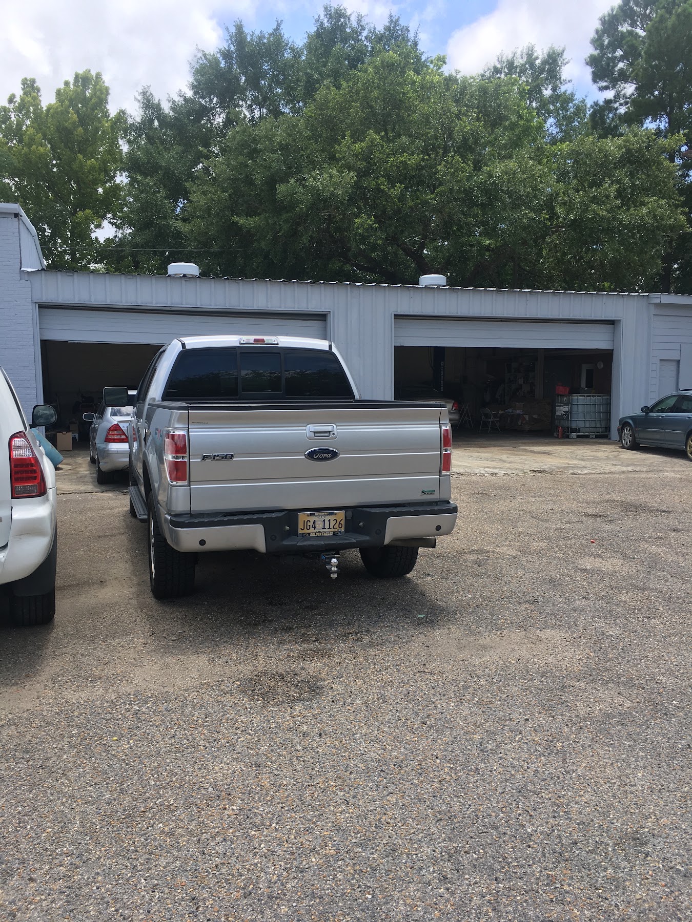 A silver pickup truck waiting outside the D and M Auto Repair service bays